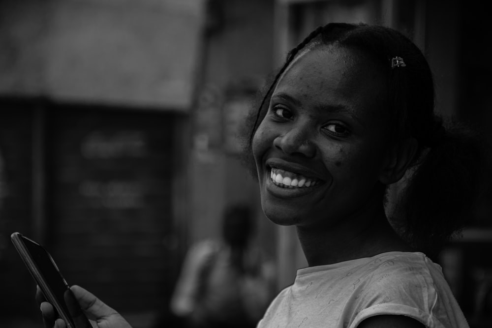 Young woman smiling while using her phone